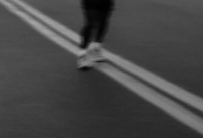 Man wearing a headlamp runs down the center of the street