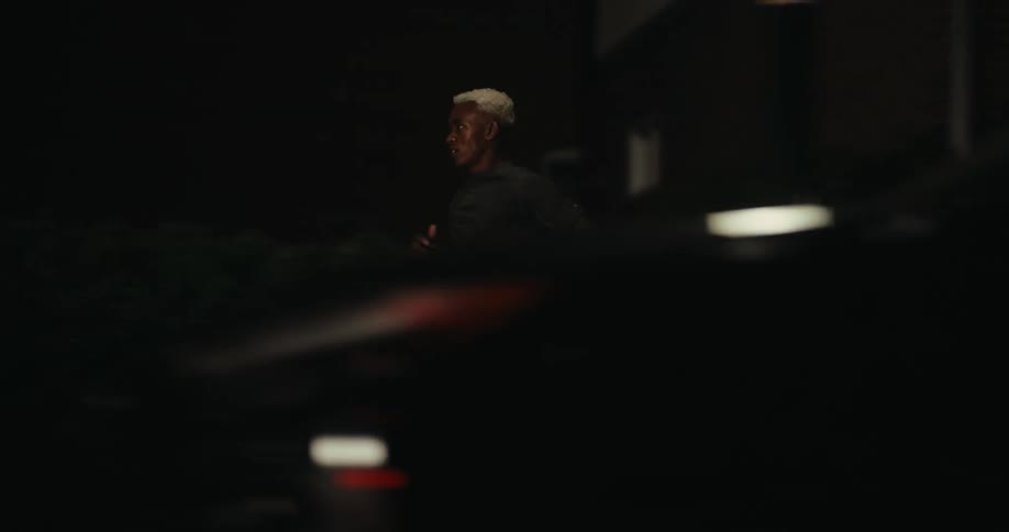 Man running in a residential neighborhood at night