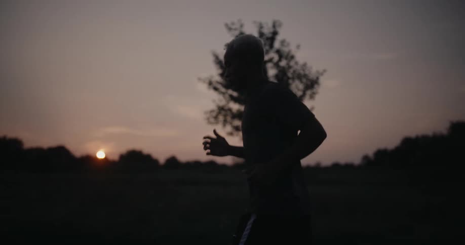 Silhouette of a man jogging at morning with the sun over the horizon
