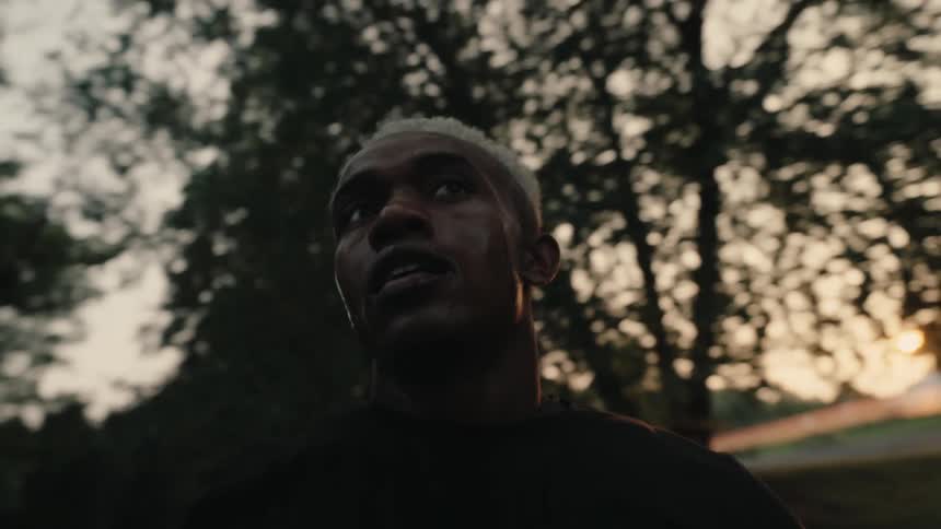 A sweaty man runs through the countryside at sunset
