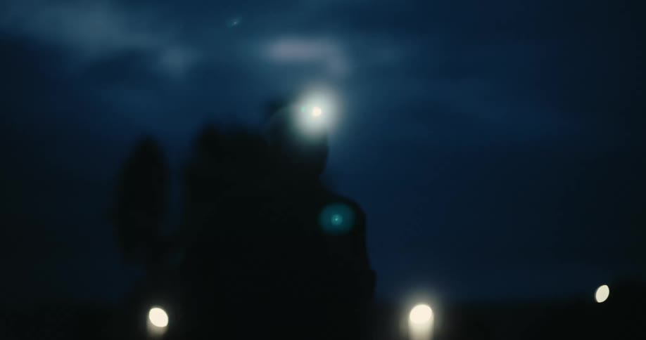 The silhouette of a person running at night and wearing a bright flashlight on his head