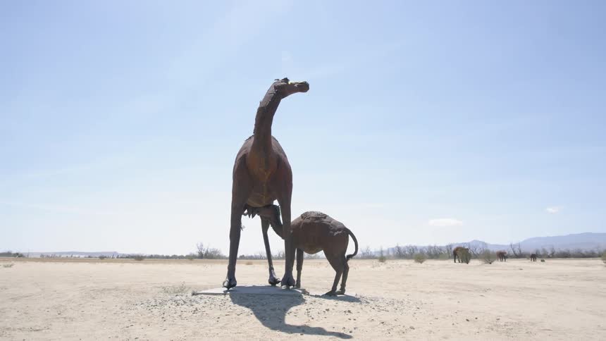 A camel statue stands in the desert