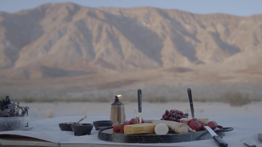 Picnic table and food set up in the middle of a desert