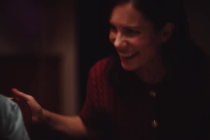 The face of a mature woman who is smiling and she stands up