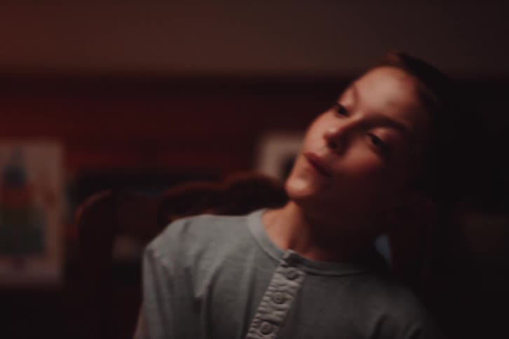 A little boy sitting in a chair is making faces while rocking from side to side