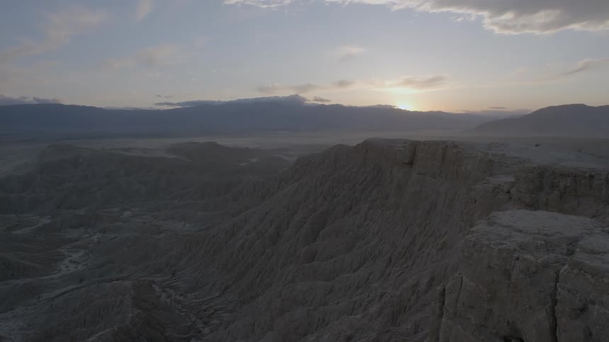 The sun sets ahead past this valley of mountains