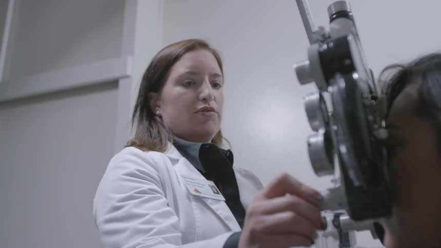 An optometrist is examining a patient's eyes