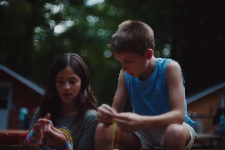 Boy and girl in a park playing with colorful threads