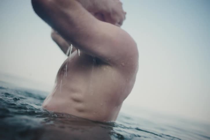 Man bathing in the sea and washing his face