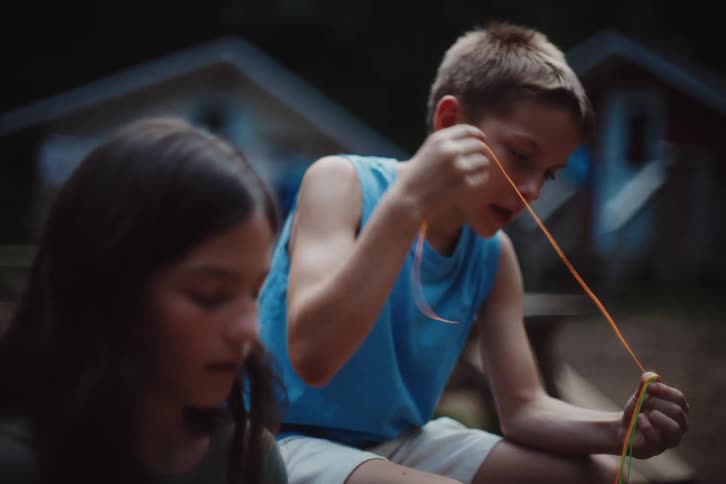 Girl and boy playing with colorful string toy