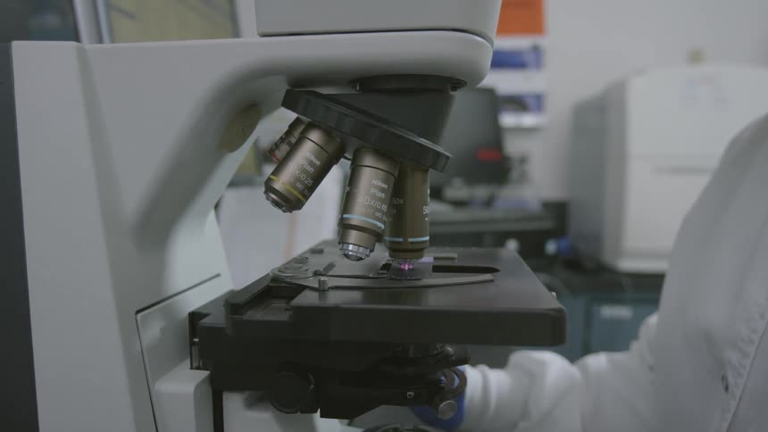 A person in a lab is using a microscope
