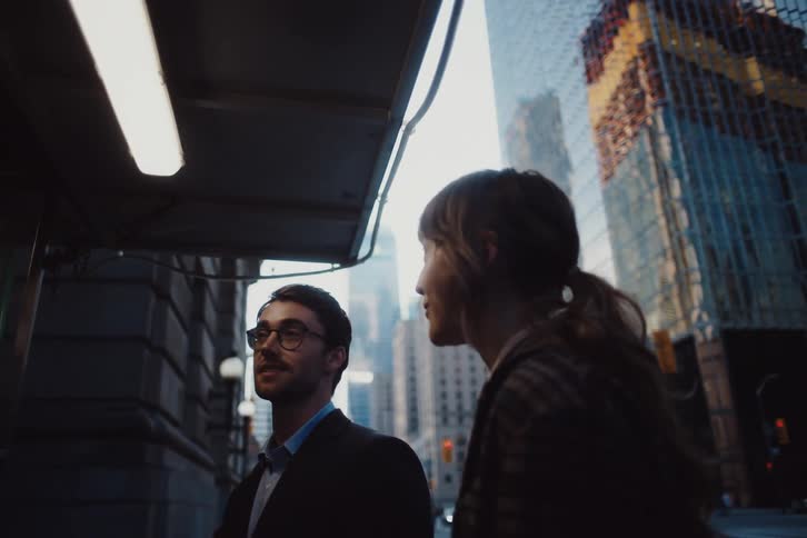 Man in a suit grabs a hot dog from a food truck while chatting with a woman next to him