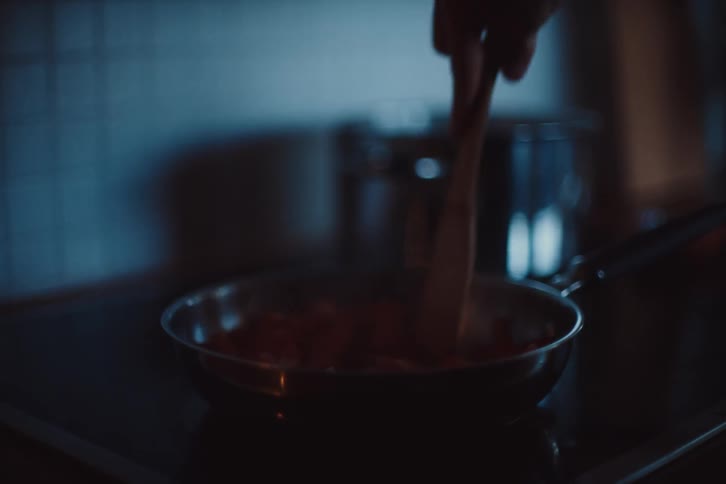 A person is cooking with a pan