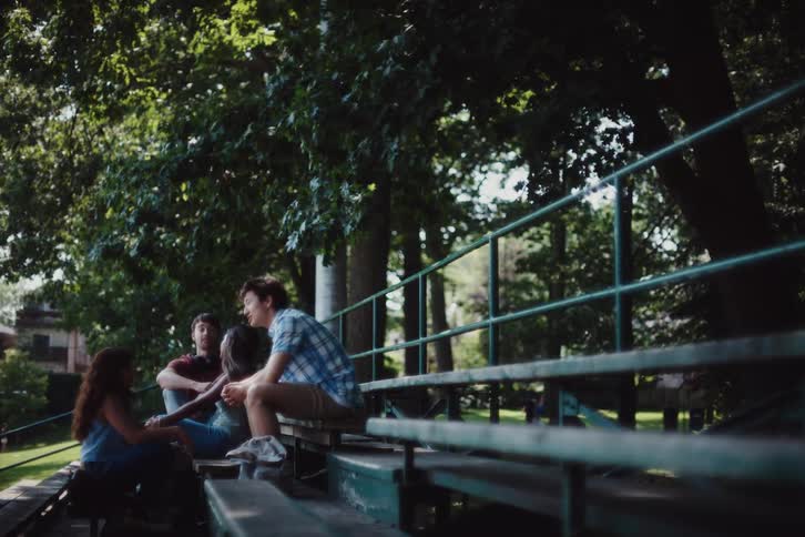 Friends talk together on the park bench