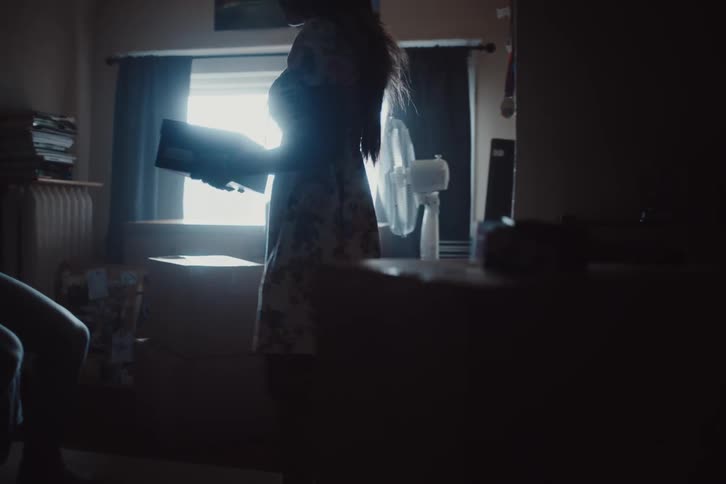 Woman nailing a box and handing it to a man