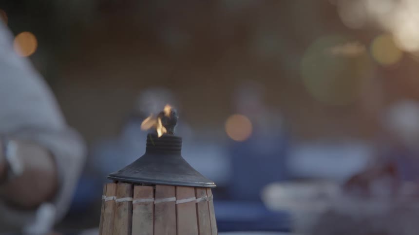 A flame burns on an outdoor torch