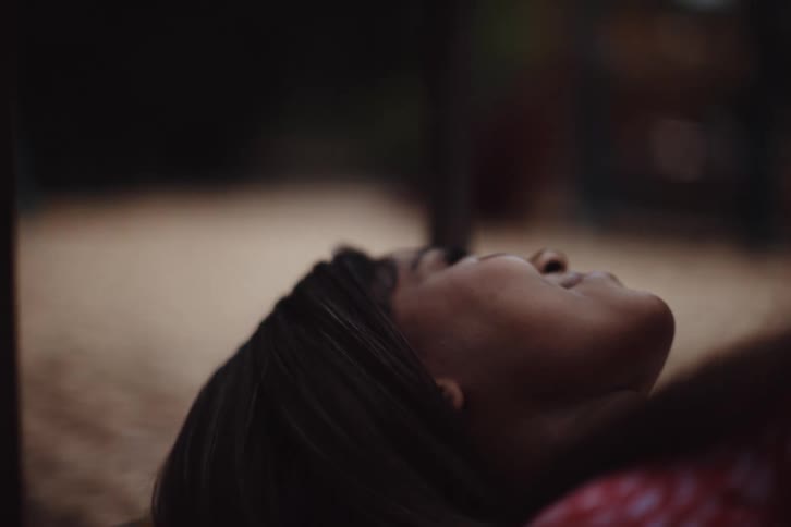 Woman lies on her back while moving past residential neighborhood terrain