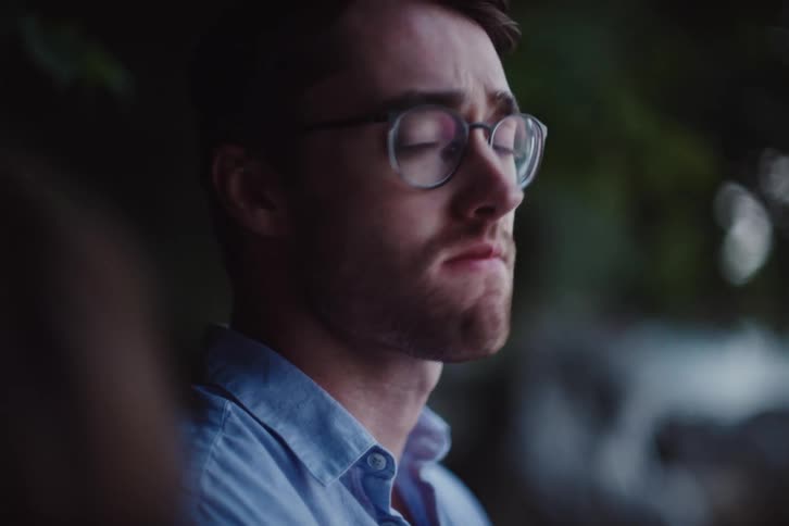 A clip of a sad person putting on and eyeglass