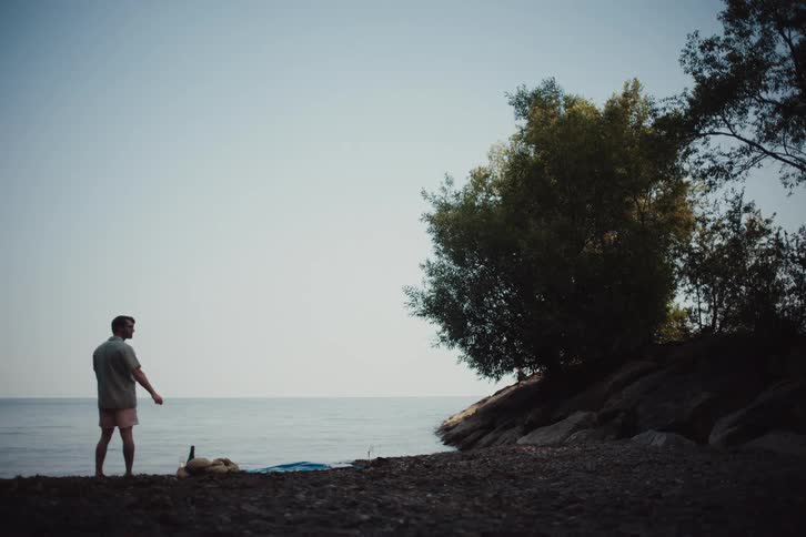 A man skips a rock on the water