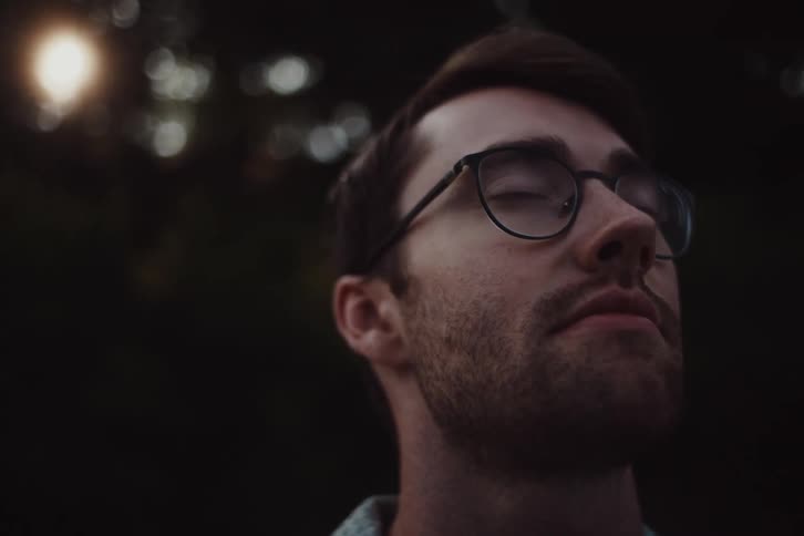 Portrait of a man with glasses and a beard in an outdoor setting