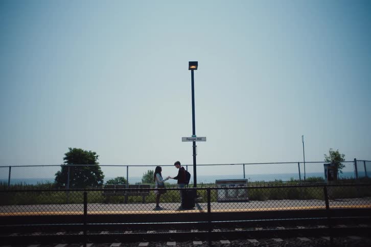 A clip of a male and female hugging at the railway
