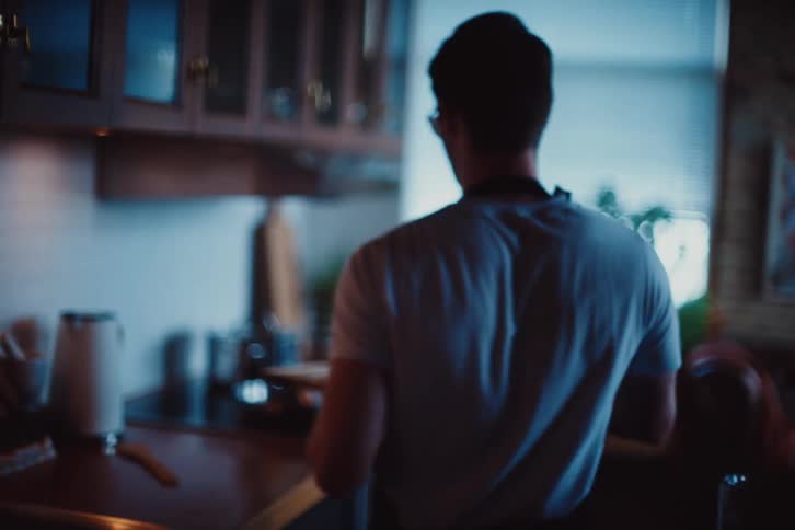 Man in apron cooking holding a knife