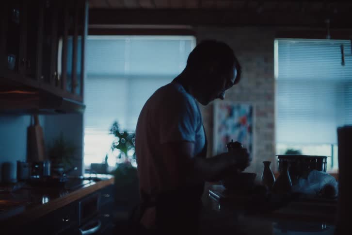 A man is cutting food and using ingredients