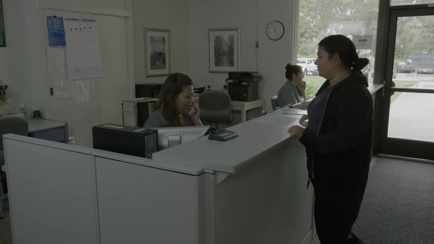 Person walking into a clinic and then being greeted by a doctor with a handshake