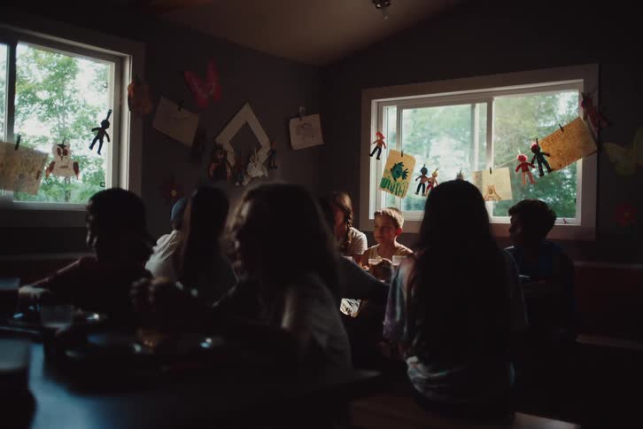 Group of children sitting at a table eating and talking