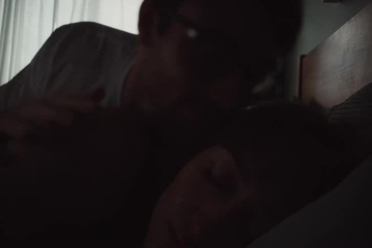 Portrait of a sleeping woman and a man getting out of bed
