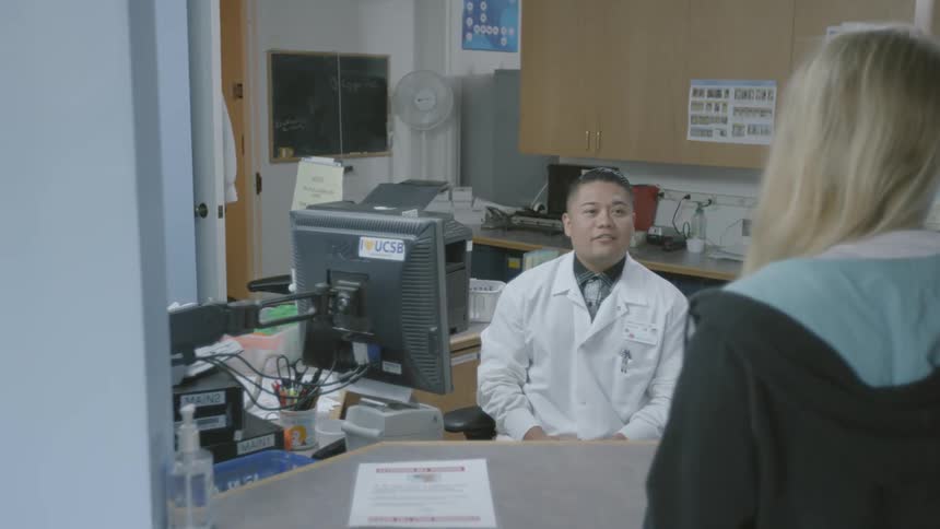 Woman talking to a doctor who is sitting at a desk