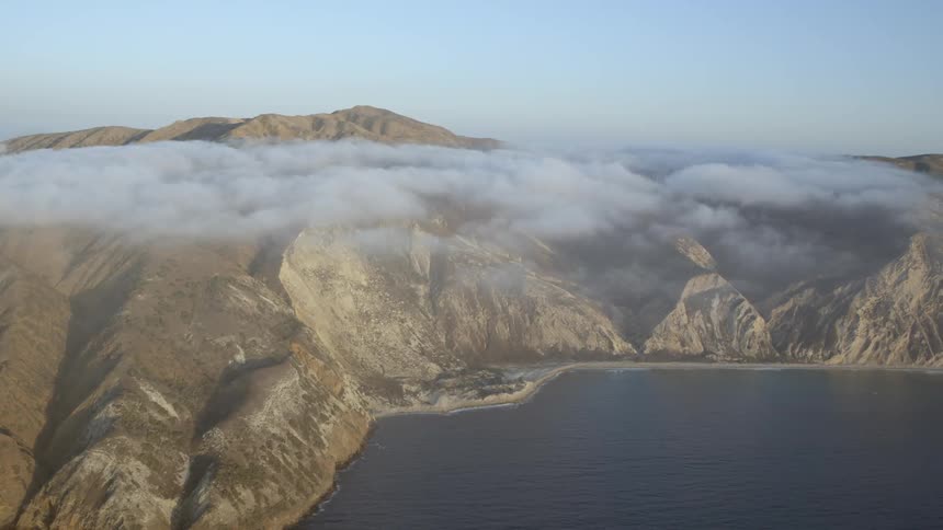 Aerial view of mountains and water on a cloudy day