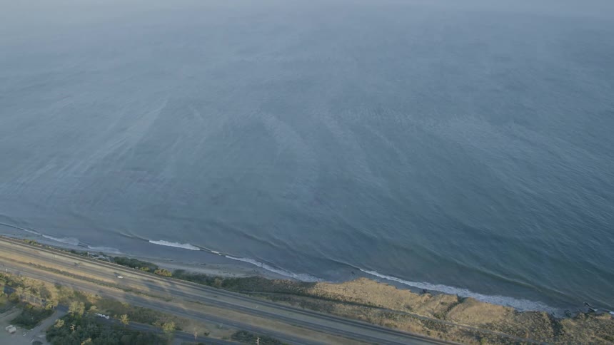 Vehicles travel on a coastal road