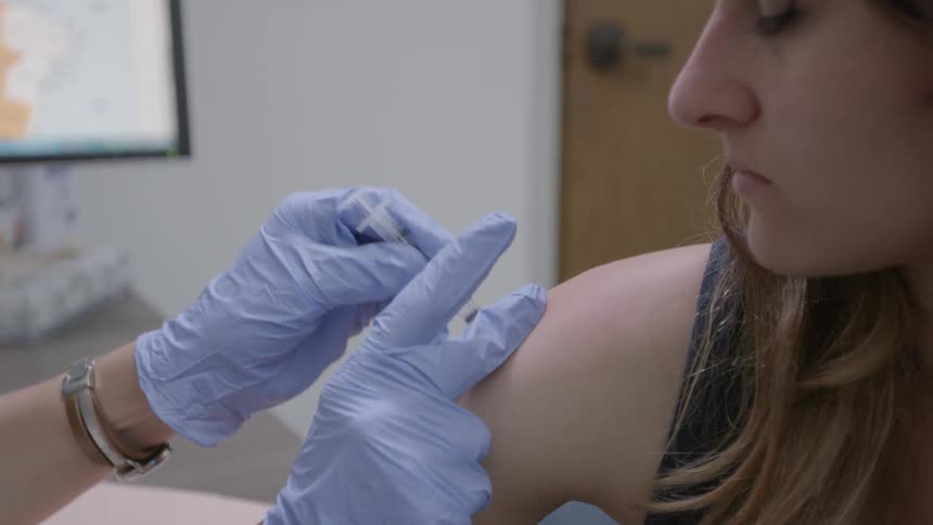 A woman is getting a shot in a doctors office