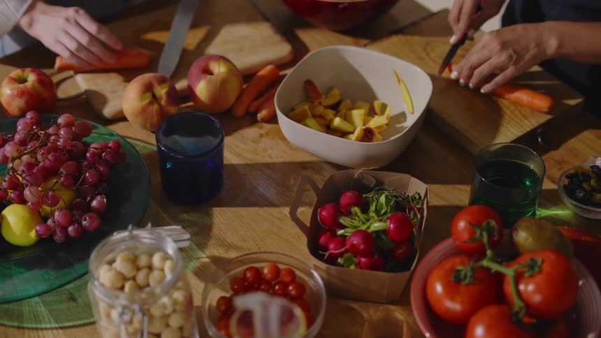 People are cutting up food at the table
