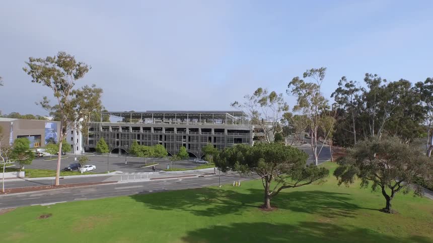 Grass and trees surround a large building