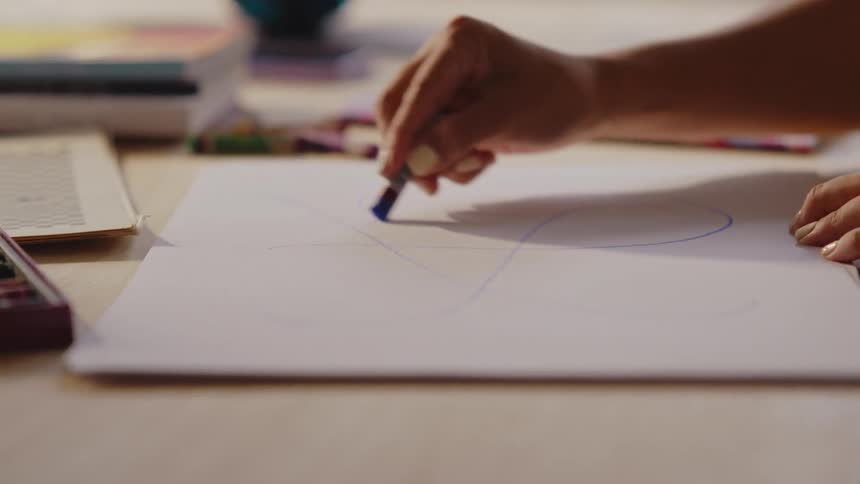 Concentrated woman drawing on a white sheet