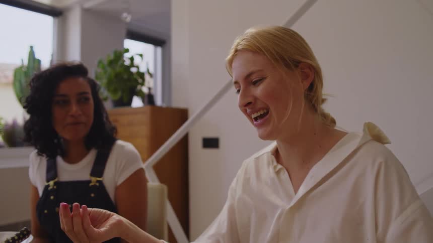 A woman is talking with friends at the dining table