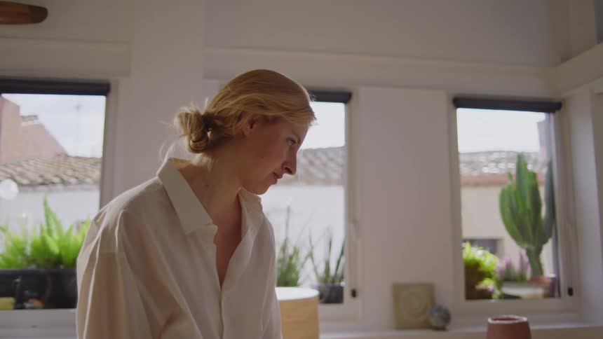 Blonde woman gestures during a talk with an artist taking a break from drawing at a table