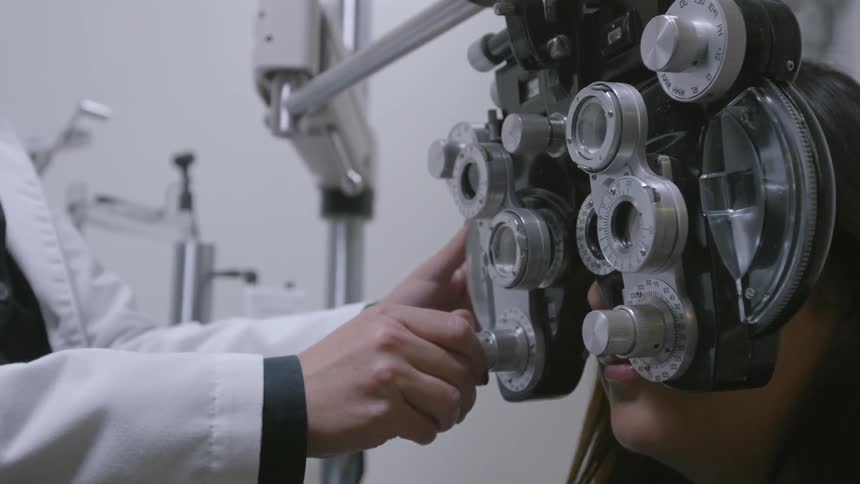 An optometrist is examining a patient's eyes