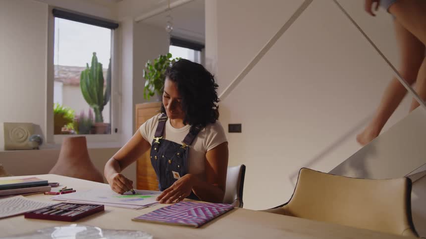 A woman is sketching as her partner climbs the stairs