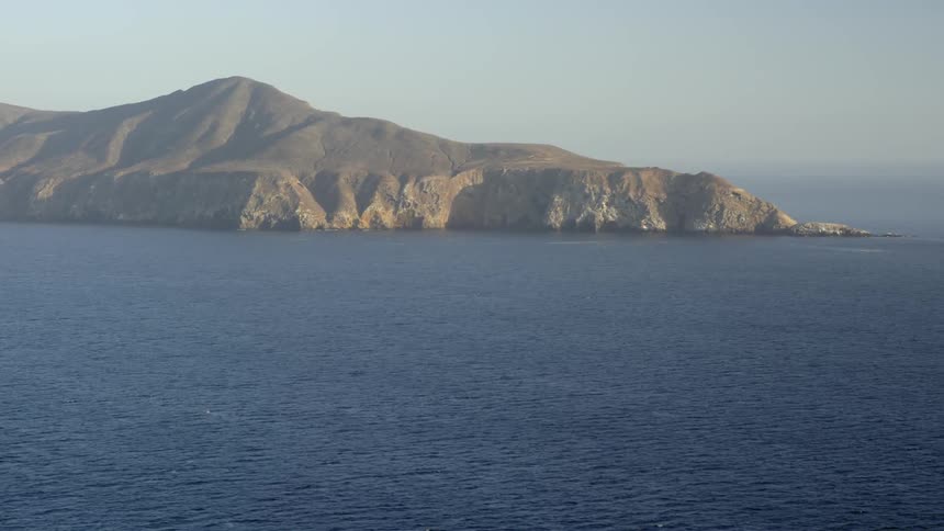 A scene of a body of water with a large mountain in the background