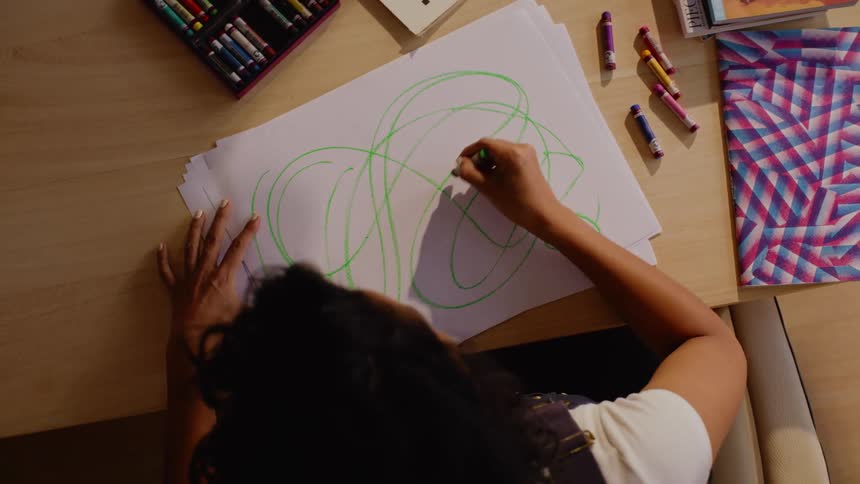 A woman is sketching on a big piece of paper