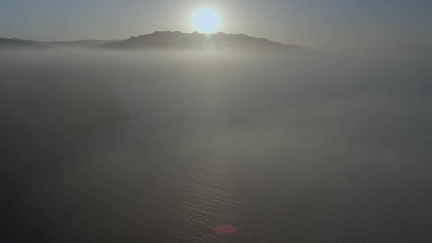 A view of the sun rising over a mountain in the distance