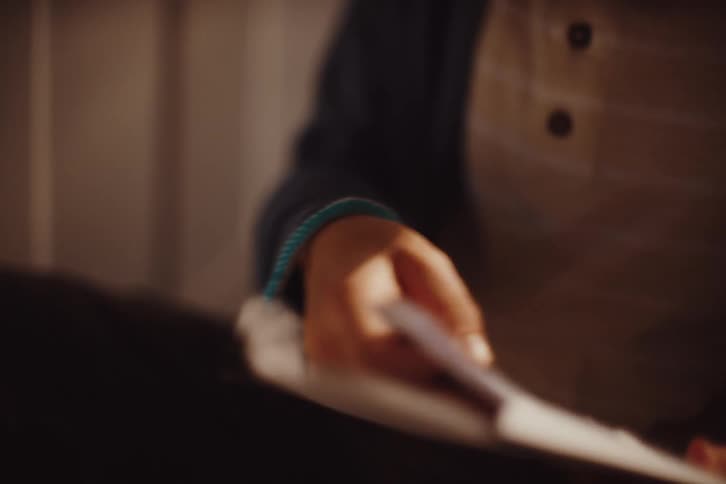 A young boy examining a bracelet and reading a letter
