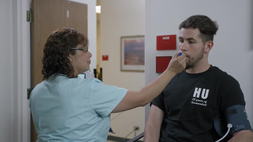 A man is getting his temperature taken by a nurse