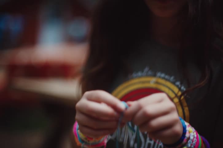 Children are using lanyard to make bracelets
