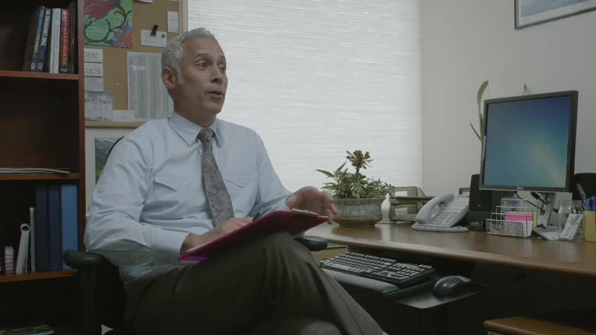 Businessman sitting in his office speaking with someone