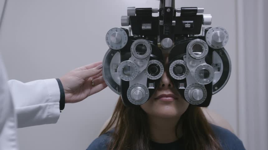 Woman looking through optometry equipment