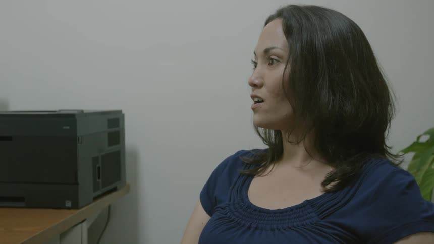A woman is sitting in an office talking